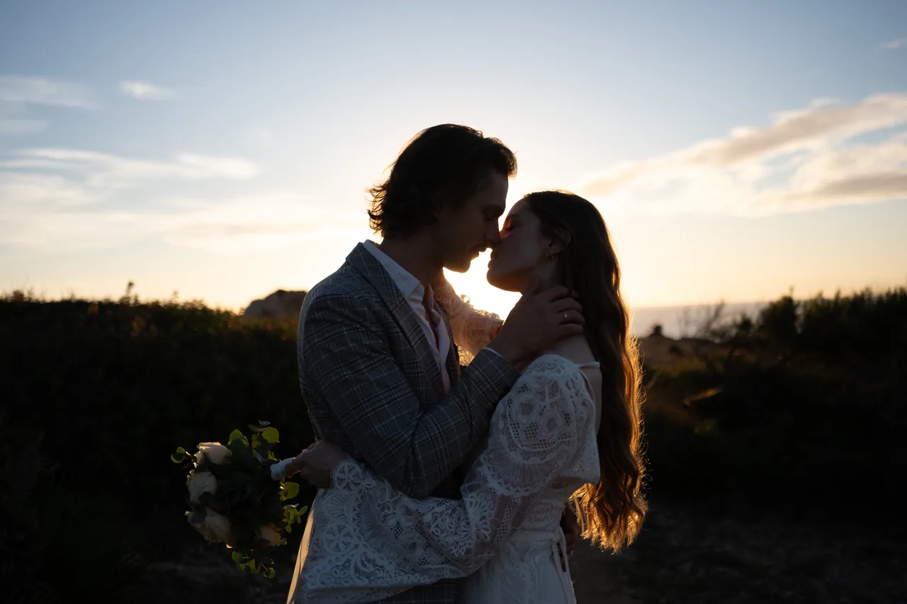 A couple kissing in warm sunset light during their elopement wedding