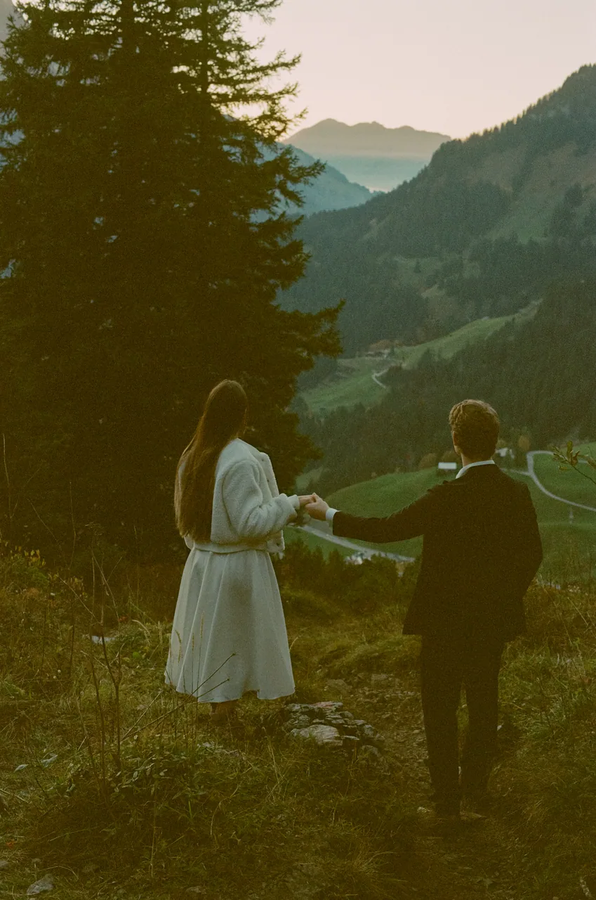 A couple holding hands above an alpine valley, shot on film