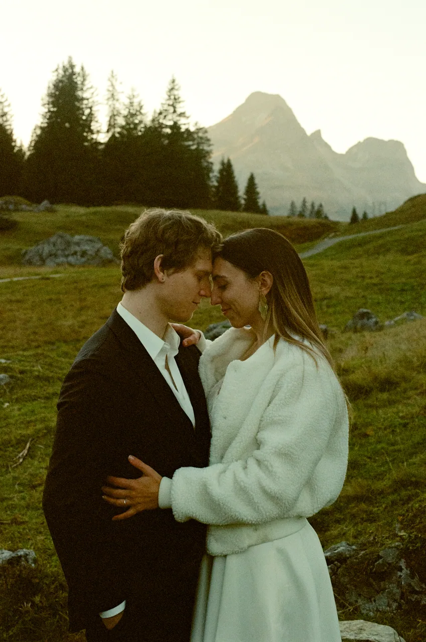 A couple embracing below an alpine peak, shot on film