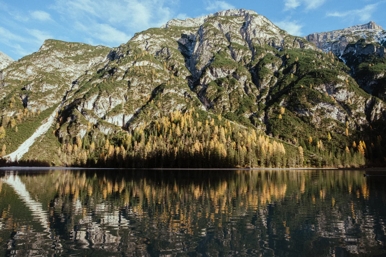 A mountain mirrored in a still Dolomites lake at first light