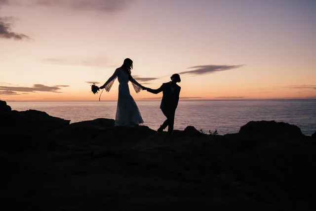 Couple walking hand in hand over a Mallorcan hill at dusk