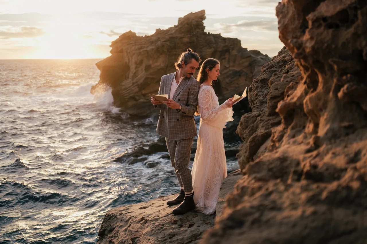 Reading vows on the rocks as the sun meets the sea