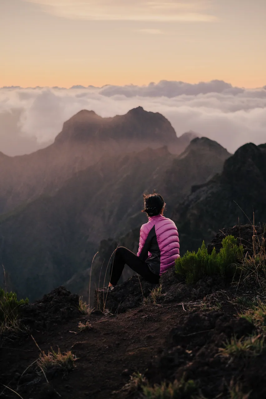 A lone figure above a sea of clouds on a Madeira peak at sunset